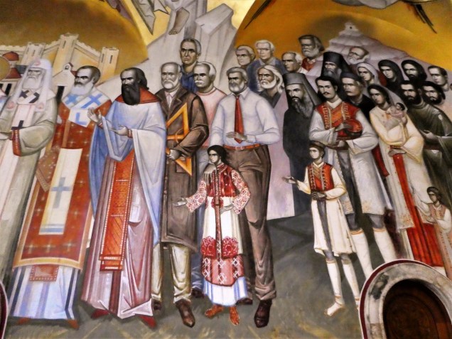 El típico fresco religioso ortodoxo con sus santos, sus sacerdotes, sus monjes, sus monaguillos y, espera, ¿qué? (Un hombre vestido de oficinista con corbata entre el resto de los personajes del fresco)